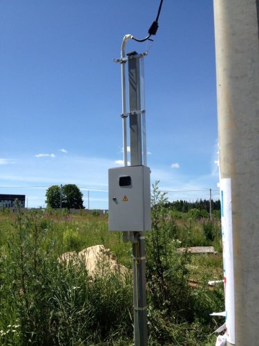 Electric meter on pipe stand at the border of the site